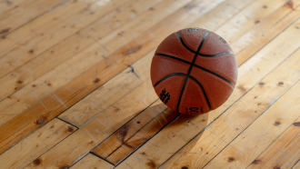 A basketball on a wooden court.